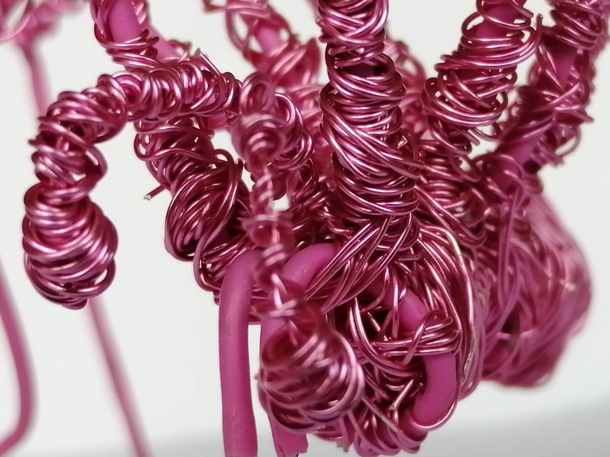A close up photo of my hand crafted Pink wire spider (head end)