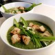 Photo of nettle soup served garnished with croutons and few flowered leek sprigs